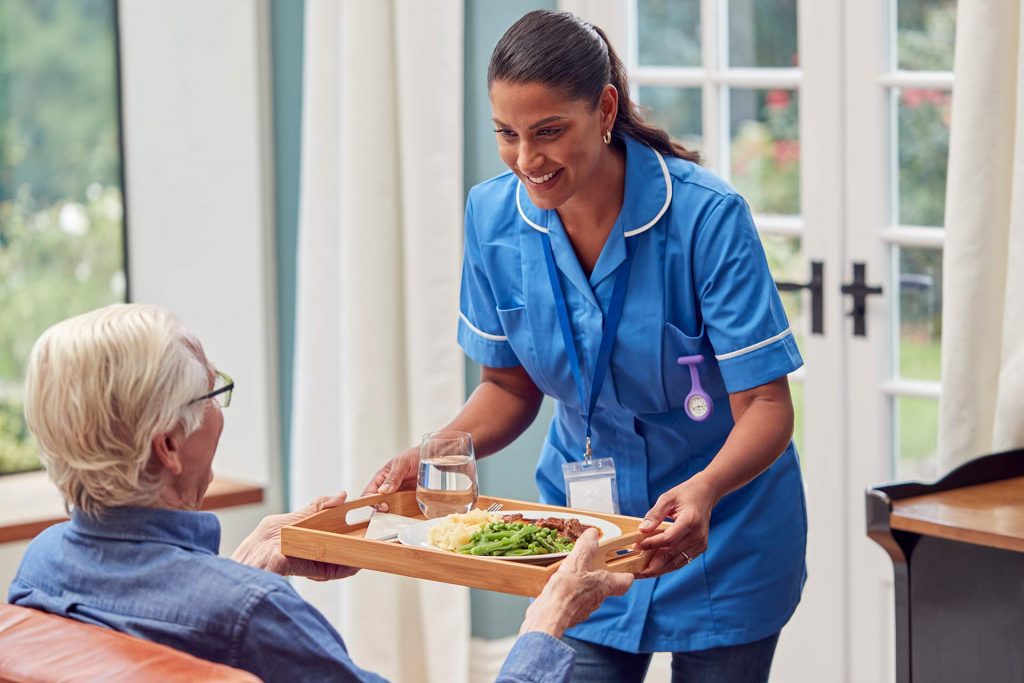 female care worker in uniform bringing meal on tra 2022 04 04 21 27 31 utc 1024x683 1